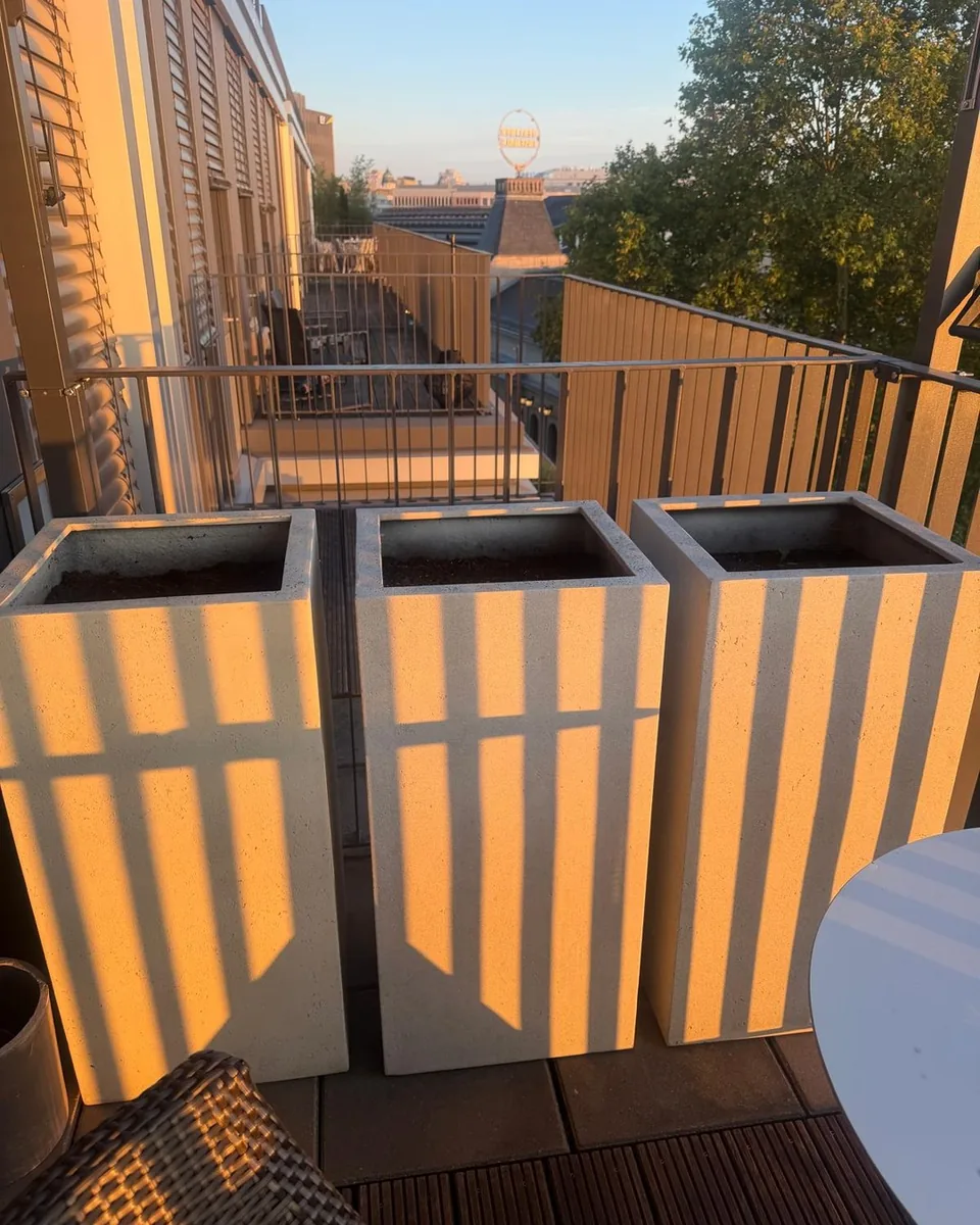 Drei leere Pflanzkübel aus Faserzement an der Brüstung einer Dachterrasse in Berlin-Mitte, vor der Bepflanzung